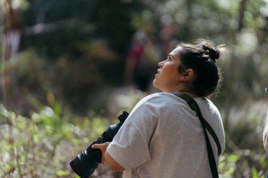 Kadın sırt çantasıyla kameraya bakıyor.
