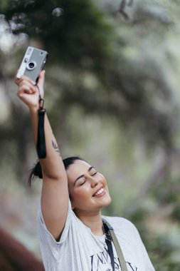 Ormanda fotoğraf çeken genç bir kız.