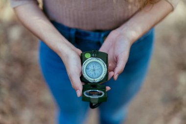 Kadın eli ormanda bir pusula tutuyor. Yaklaş.