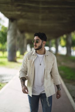 Sokakta poz veren sakallı genç adam.