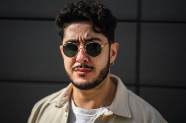 Şehrin sokaklarında güneş gözlüğü takmış yakışıklı bir adam.