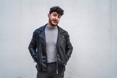 Gri ceketli gülümseyen genç bir adamın portresi.