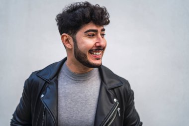 Gülümseyen deri ceketli genç adam.