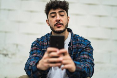 Duvarında cep telefonu olan yakışıklı bir adamın portresi.