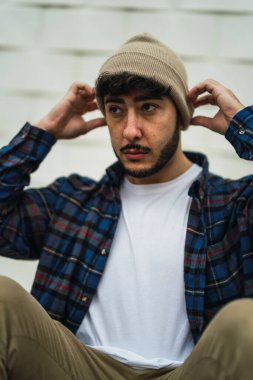 Genç yakışıklı adam tahta bir kutuda poz veriyor.