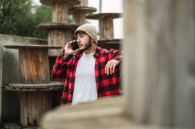 Genç adam cep telefonuyla konuşuyor.