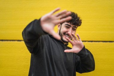 Sakallı genç ve yakışıklı bir adam selfie çekiyor.