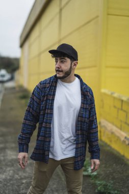 Şehirde sakallı ve bıyıklı bir gencin portresi.