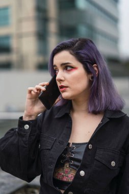 Sokakta cep telefonu kullanan bir kadın.