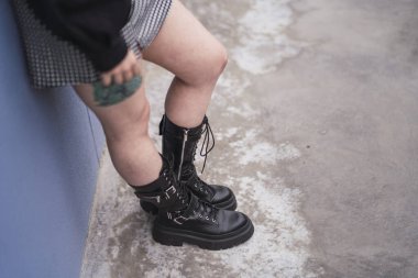 Siyah çizmeli ve kot pantolonlu kadın.