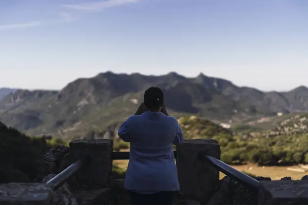 Genç bir kız tepenin kenarında duruyor ve kameraya bakıyor. yüksek kaliteli fotoğraf