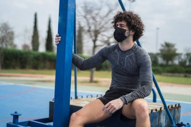 Genç adam halka açık bir parkta egzersiz yapıyor..