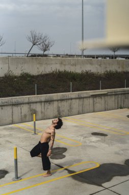 Sokakta yoga egzersizi yapan genç adam..