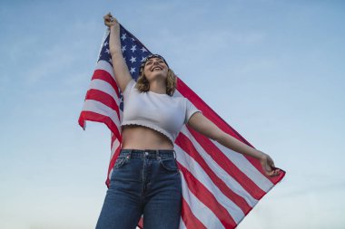 Amerikan bayrağı tutan güzel bir genç kızın portresi.