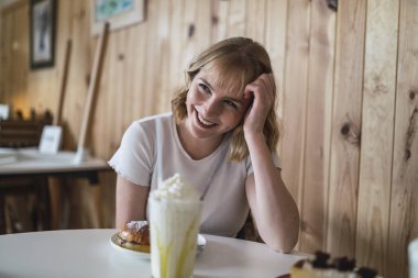 Kafede pasta yiyen güzel bir kadın.