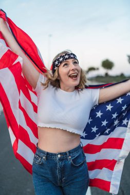 Amerika bayrağı taşıyan genç mutlu kadın.