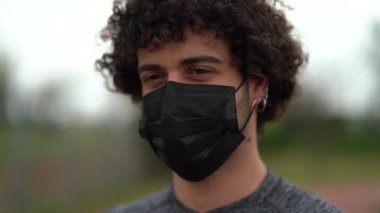 Yüz maskeli genç adamın portresini kapat.
