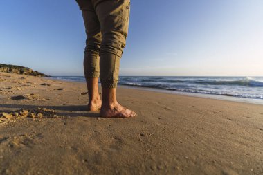 Kumsalda yürüyen bir kadın