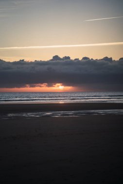 Gün batımında bir kumsalın güzel bir görüntüsü. Arka planda renkli bir gökyüzü, İspanya.