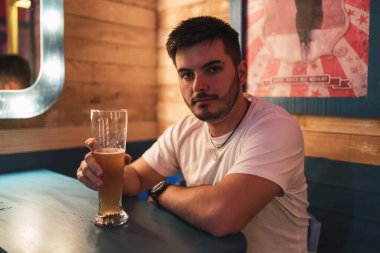 Barda bira içen genç adamın portresi.