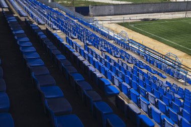 Stadyumdaki boş koltuklar, futbol sahası.