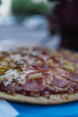 Peynirli pizza, zeytin, domates ve sosis.