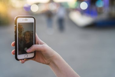 Akıllı telefonuyla selfie çeken genç kadın.