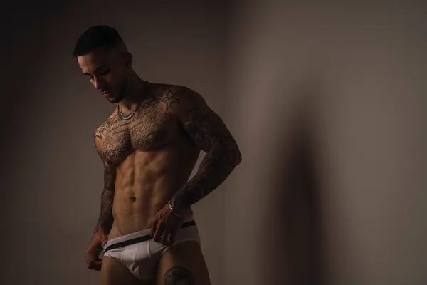 Stüdyoda poz veren kaslı bir erkek.