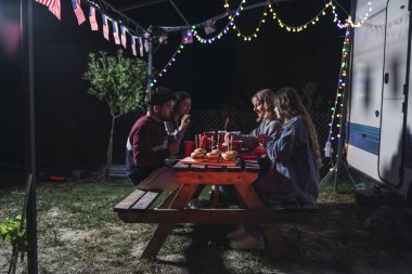 Genç arkadaşlar gece kamp yaparken piknik yapıyorlar.