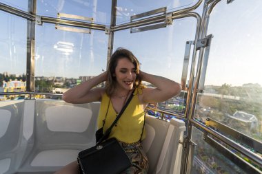 Genç bir kadın lunaparkta gezintiden zevk alıyor.