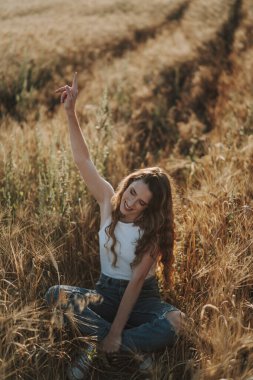 Genç kadın tarlada poz veriyor.