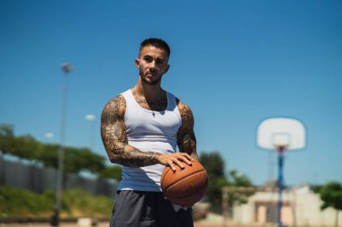 Sahada basketbol oynayan yakışıklı bir adamın portresi