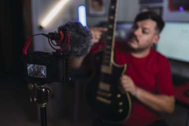 Genç adam dijital kameraya video kaydediyor.