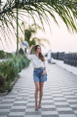 Kumsalda şapkalı bir kadın