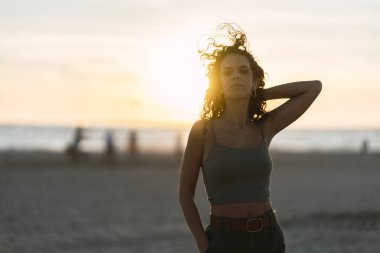 Sahilde gün batımında genç bir kızın portresi.