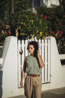 Sokakta poz veren şık elbiseli güzel esmer manken.