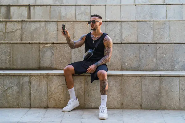 Sokakta akıllı telefonu olan genç bir adam.