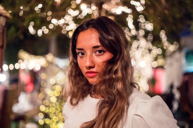 Geceleri poz veren uzun saçlı genç bir kadın.