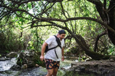 Nehirde sırt çantalı bir adam.