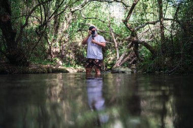 Nehirde kameralı bir adam
