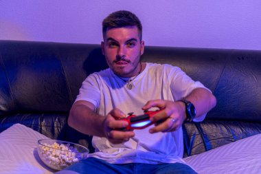 Adam bir odada uzaktan kumandayla oyun oynuyor