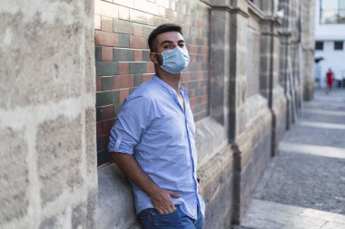 Sokakta maske takan genç adam.