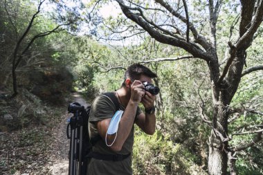 Ormanda kameralı bir fotoğrafçı.