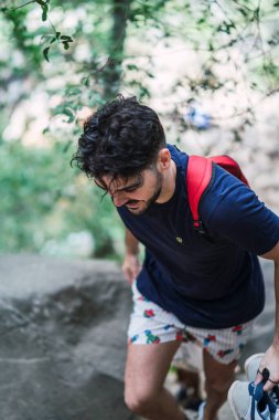 Ormanda sırt çantası ve sırt çantası olan bir adam.