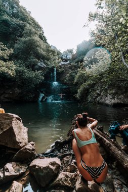 Şelalede oturan genç kadın