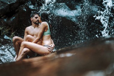 Güzel bir çift dağlarda şelalenin tadını çıkarıyor..