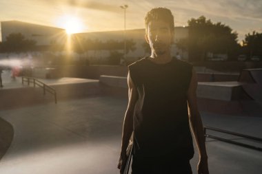 Gün batımında kaykaylı genç bir adam