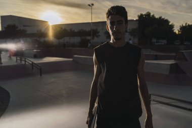 Parkta dövmeleri olan genç bir adam.