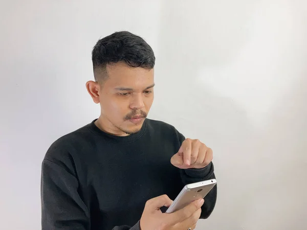 Jovem Asiático Homem Mostra Rosto Confuso Enquanto Apontando Para Smartphone — Fotografia de Stock