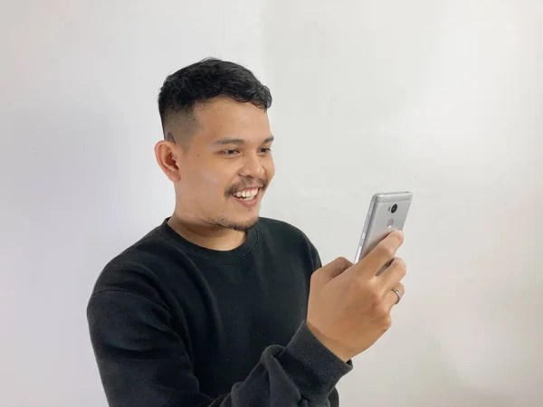 Genç Asyalı Bir Adam Akıllı Telefona Bakarken Gülümsüyor — Stok fotoğraf